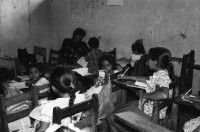 Image of sheet 19950140 photo 11: In der Dorfschule Maurice Demierrre in der Cooperative Santiago Arauz in  Lagartillo bei Achuapa. Die Lehrerin der 2./ 3. und 4. Klasse heisst Janet Alvaro Taruno, 31. Die Lehrerin mit langen Haaren heisst: Digna Reyes, 25. 1. und 4. Klasse. Turnen im Freien. Kinder in Uniformen und an Wandtafel. 1995 Nicaragua