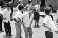 Image of sheet 19950140 photo 24: In der Dorfschule Maurice Demierrre in der Cooperative Santiago Arauz in  Lagartillo bei Achuapa. Die Lehrerin der 2./ 3. und 4. Klasse heisst Janet Alvaro Taruno, 31. Die Lehrerin mit langen Haaren heisst: Digna Reyes, 25. 1. und 4. Klasse. Turnen im Freien. Kinder in Uniformen und an Wandtafel. 1995 Nicaragua