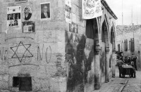 Image of sheet 19960060 photo 10: Strassenszene King Salomon Street Nr. 1-3 und Nr. 9- 24 mit Wahlpropadanda und NO + Davidstern graffitti. In der Altstadt Jerusalem Salbungsstein (hier wurde der Leichnam Christi gesalbt) in der Grabeskirche 3 griechisch-orthodoxe Altare im Kalvarienberg  rechts der Kreuzannagelungsaltar (von 1588) in der Mitte der (ebenfalls den Katholiken gehörende) Stabat-Mater-Altar links der Kreuzigungsaltar der Orthodoxen mit Loch in dem das Kreuz stand, und die Felsplatte,die sich nach der Kreuzigung öffnete. Auf dem Kalvarienberg werden Stationen X-XIII des Kreuzweges angenommen. Sicht auf die Altstadt vom Ölberg, Berg Ophel. Jüdischer Friedhof mit betenden Juden und Junge mit Esel. Israel 1996
