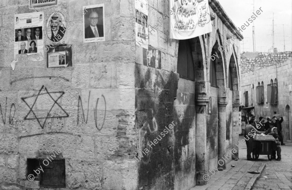 Image of sheet 19960060 photo 10: Strassenszene King Salomon Street Nr. 1-3 und Nr. 9- 24 mit Wahlpropadanda und NO + Davidstern graffitti. In der Altstadt Jerusalem Salbungsstein (hier wurde der Leichnam Christi gesalbt) in der Grabeskirche 3 griechisch-orthodoxe Altare im Kalvarienberg  rechts der Kreuzannagelungsaltar (von 1588) in der Mitte der (ebenfalls den Katholiken gehörende) Stabat-Mater-Altar links der Kreuzigungsaltar der Orthodoxen mit Loch in dem das Kreuz stand, und die Felsplatte,die sich nach der Kreuzigung öffnete. Auf dem Kalvarienberg werden Stationen X-XIII des Kreuzweges angenommen. Sicht auf die Altstadt vom Ölberg, Berg Ophel. Jüdischer Friedhof mit betenden Juden und Junge mit Esel. Israel 1996