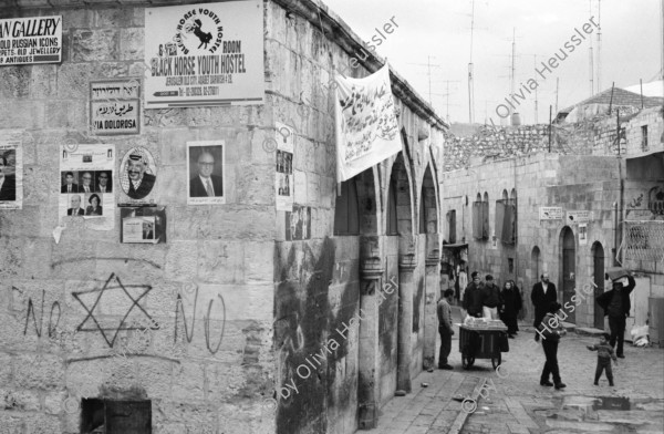 Image of sheet 19960060 photo 11: Strassenszene King Salomon Street Nr. 1-3 und Nr. 9- 24 mit Wahlpropadanda und NO + Davidstern graffitti. In der Altstadt Jerusalem Salbungsstein (hier wurde der Leichnam Christi gesalbt) in der Grabeskirche 3 griechisch-orthodoxe Altare im Kalvarienberg  rechts der Kreuzannagelungsaltar (von 1588) in der Mitte der (ebenfalls den Katholiken gehörende) Stabat-Mater-Altar links der Kreuzigungsaltar der Orthodoxen mit Loch in dem das Kreuz stand, und die Felsplatte,die sich nach der Kreuzigung öffnete. Auf dem Kalvarienberg werden Stationen X-XIII des Kreuzweges angenommen. Sicht auf die Altstadt vom Ölberg, Berg Ophel. Jüdischer Friedhof mit betenden Juden und Junge mit Esel. Israel 1996