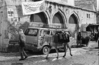 Image of sheet 19960060 photo 2: Strassenszene King Salomon Street Nr. 1-3 und Nr. 9- 24 mit Wahlpropadanda und NO + Davidstern graffitti. In der Altstadt Jerusalem Salbungsstein (hier wurde der Leichnam Christi gesalbt) in der Grabeskirche 3 griechisch-orthodoxe Altare im Kalvarienberg  rechts der Kreuzannagelungsaltar (von 1588) in der Mitte der (ebenfalls den Katholiken gehörende) Stabat-Mater-Altar links der Kreuzigungsaltar der Orthodoxen mit Loch in dem das Kreuz stand, und die Felsplatte,die sich nach der Kreuzigung öffnete. Auf dem Kalvarienberg werden Stationen X-XIII des Kreuzweges angenommen. Sicht auf die Altstadt vom Ölberg, Berg Ophel. Jüdischer Friedhof mit betenden Juden und Junge mit Esel. Israel 1996