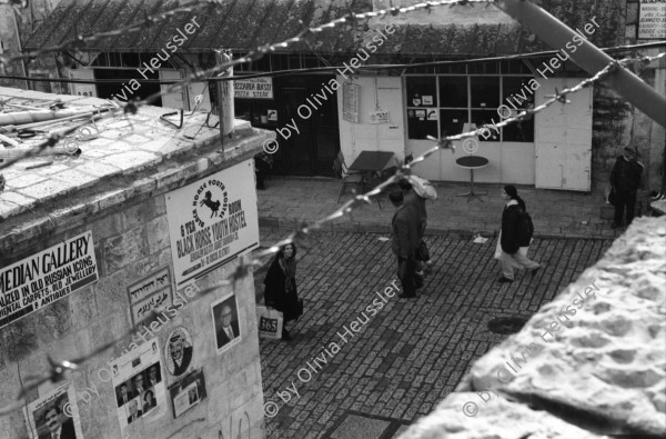 Image of sheet 19960060 photo 21: Strassenszene King Salomon Street Nr. 1-3 und Nr. 9- 24 mit Wahlpropadanda und NO + Davidstern graffitti. In der Altstadt Jerusalem Salbungsstein (hier wurde der Leichnam Christi gesalbt) in der Grabeskirche 3 griechisch-orthodoxe Altare im Kalvarienberg  rechts der Kreuzannagelungsaltar (von 1588) in der Mitte der (ebenfalls den Katholiken gehörende) Stabat-Mater-Altar links der Kreuzigungsaltar der Orthodoxen mit Loch in dem das Kreuz stand, und die Felsplatte,die sich nach der Kreuzigung öffnete. Auf dem Kalvarienberg werden Stationen X-XIII des Kreuzweges angenommen. Sicht auf die Altstadt vom Ölberg, Berg Ophel. Jüdischer Friedhof mit betenden Juden und Junge mit Esel. Israel 1996