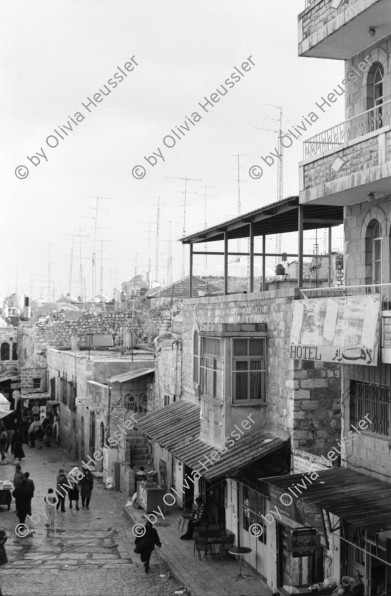 Image of sheet 19960060 photo 24: Strassenszene King Salomon Street Nr. 1-3 und Nr. 9- 24 mit Wahlpropadanda und NO + Davidstern graffitti. In der Altstadt Jerusalem Salbungsstein (hier wurde der Leichnam Christi gesalbt) in der Grabeskirche 3 griechisch-orthodoxe Altare im Kalvarienberg  rechts der Kreuzannagelungsaltar (von 1588) in der Mitte der (ebenfalls den Katholiken gehörende) Stabat-Mater-Altar links der Kreuzigungsaltar der Orthodoxen mit Loch in dem das Kreuz stand, und die Felsplatte,die sich nach der Kreuzigung öffnete. Auf dem Kalvarienberg werden Stationen X-XIII des Kreuzweges angenommen. Sicht auf die Altstadt vom Ölberg, Berg Ophel. Jüdischer Friedhof mit betenden Juden und Junge mit Esel. Israel 1996