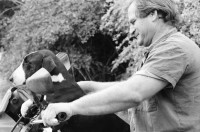 Image of sheet 19960130 photo 14: Schreiner Stuart Franks im Kibbutz Yasuur Kleinladen ohne Geld Junge Hunde auf Motorrad Barbara und ihr Mann Im Kibbutz unter Baum Im Laden Afula Sav-Yom Day Care Center Physiotherapie für RentnerInnen Rentner Israel 1996