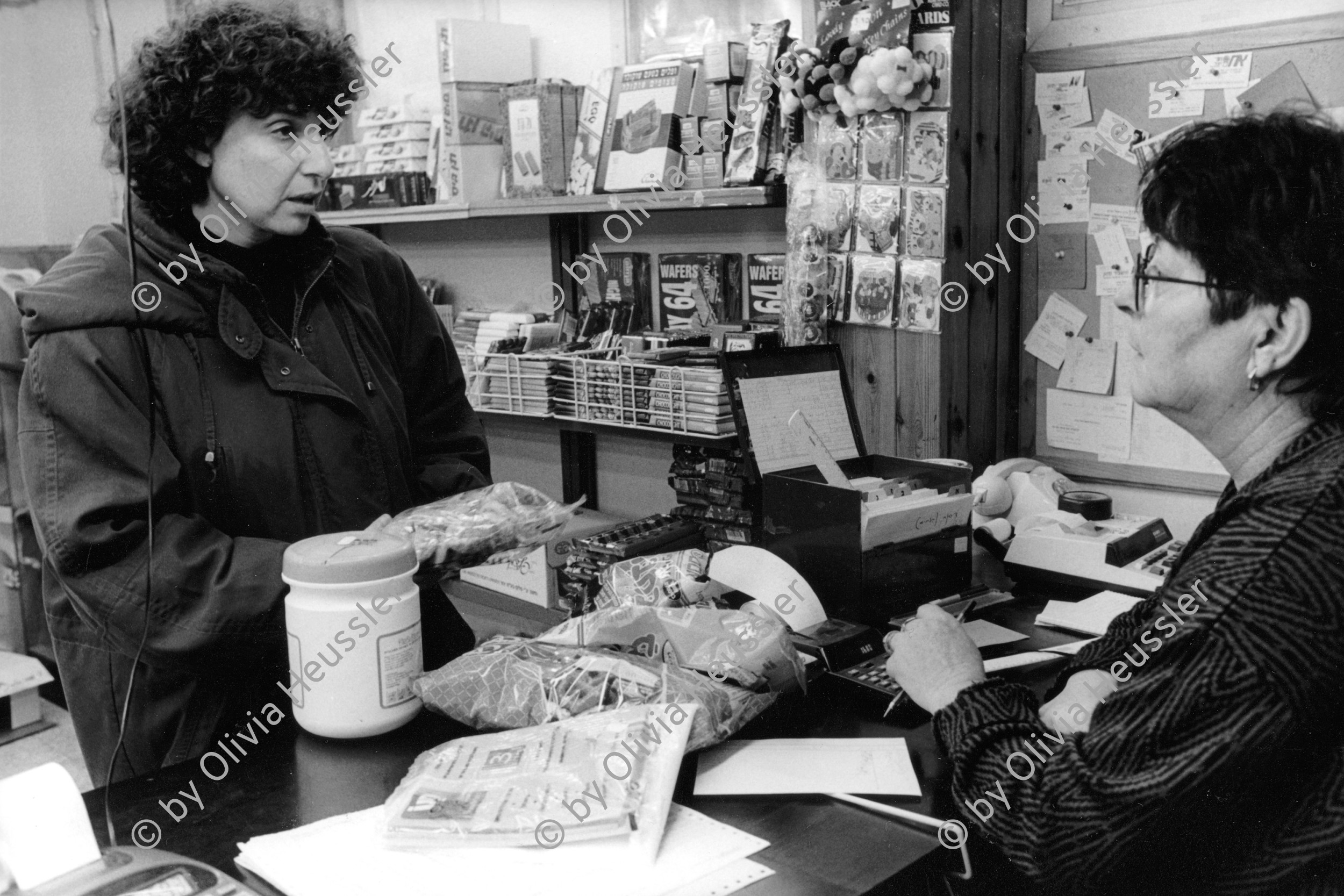 Image of sheet 19960130 photo 29: © 1996, Olivia Heussler / www.clic.li
Im bargeldlosen Einkaufsladen.  Kibbutz Yasuur. Israel 1996

Store without cash. Only by credit. √ Women talking shop food

Yas'ur (Hebrew: יַסְעוּר, lit. petrel) is a kibbutz in northern Israel. Located east of Acre in the Western Galilee, it falls under the jurisdiction of Mateh Asher Regional Council. In 2006 it had a population of 287.

The kibbutz was established in 1949 by immigrants from England and Hungary who were members of the Zionist Socialist youth movement Hashomer Hatzair