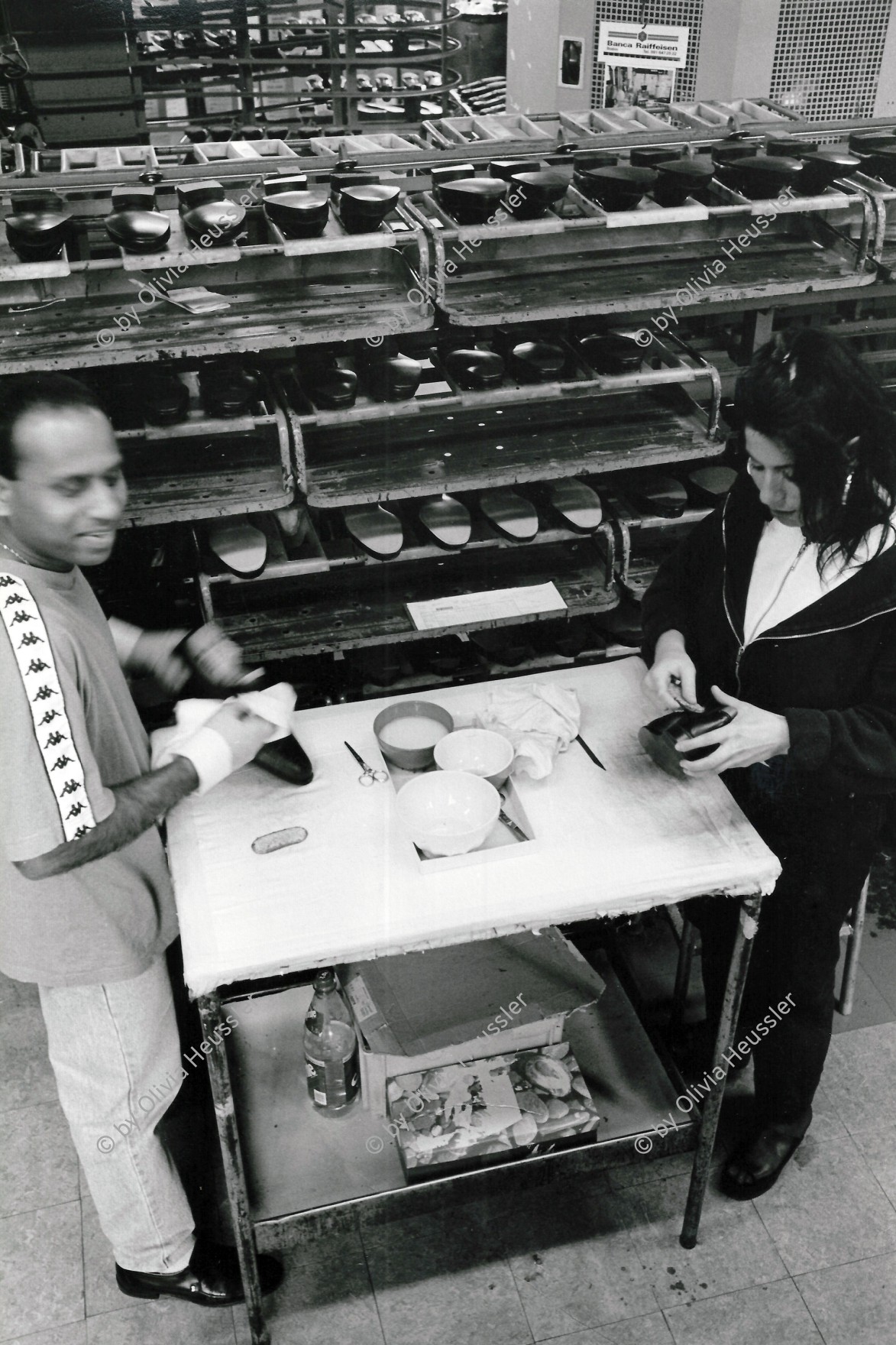 Image of sheet 19960370 photo 33: Frau und Mann Arbeiter und Arbeiterin Schuhe leimen am Fliessband. Schuhfabrik Bally in Stabio, Tessin Schweiz. 20.05. 1996 √
Worker in a shoe factory when polishing shoes glue on an assembly line. Bally shoe factory
Switzerland Swiss shoe industry Bally shoes Canton Ticino
Bally Schuhwerk Stabio Tessin Switzerland Schweiz Ticino 1996 Aus: 

© 1996, OLIVIA HEUSSLER / www.clic.li