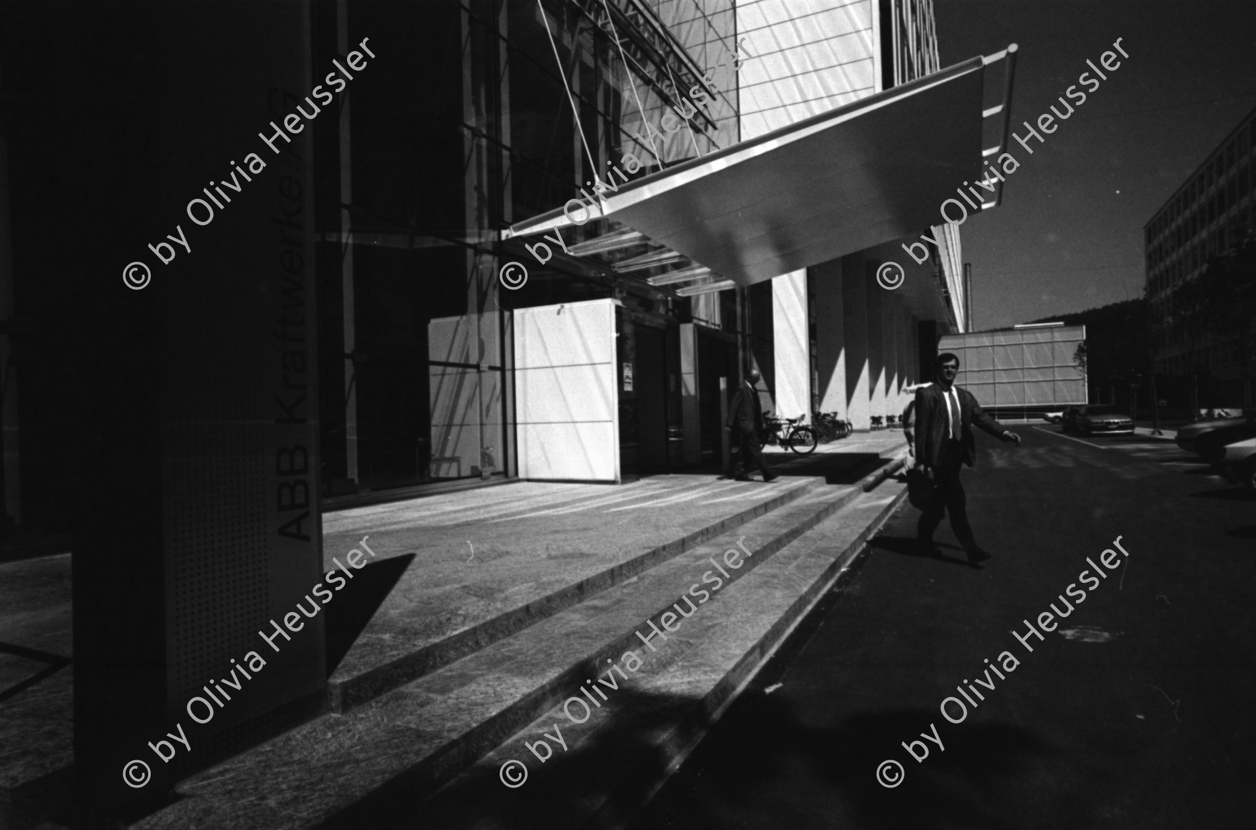 Image of sheet 19960440 photo 29: Mann mit Dächlikappe Basketmütze und Schürze Sicherheits Arbeits Schuhe SUVA Alte grösste Halle der Schweiz im Abbruch von Innen ABB Kraftwerke AG Gebäude Hauptsitz Ersatzteil Lager Turbo System Peter Meier am Arbeitsplatz Kanton Aargau Baden Aus: Schichtwechsel 1996

1891 ist ein denkwürdiges Jahr. Charles E. Brown und Walter Boveri gründen die Brown, Boveri & Cie. in Baden. Es beginnt eine eindrückliche Erfolgsgeschichte, die nachhaltige Spuren in der Schweizer Wirtschaft hinterlässt. Das elektrotechnische Unternehmen vollbringt eine Pionierleistung nach der anderen, erschliesst sich neue Märkte und wächst in einem Tempo, dass einem der Atem stockt