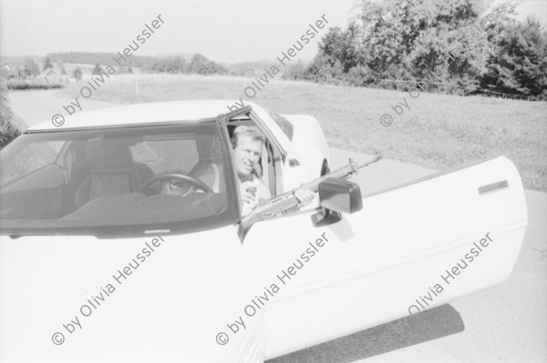 Image of sheet 19960730 photo 17: frtsg. Bettina Bräm auf Corvette mit Sturmgewehr vor Cannabisfeld. Arbeit macht frei. Vom Toitland Europa. Akko Theater Zentrum Israel am Zürcher Theaterspektakel. Mit Nr. 34 Haled Abu Ali. Zürich 1996