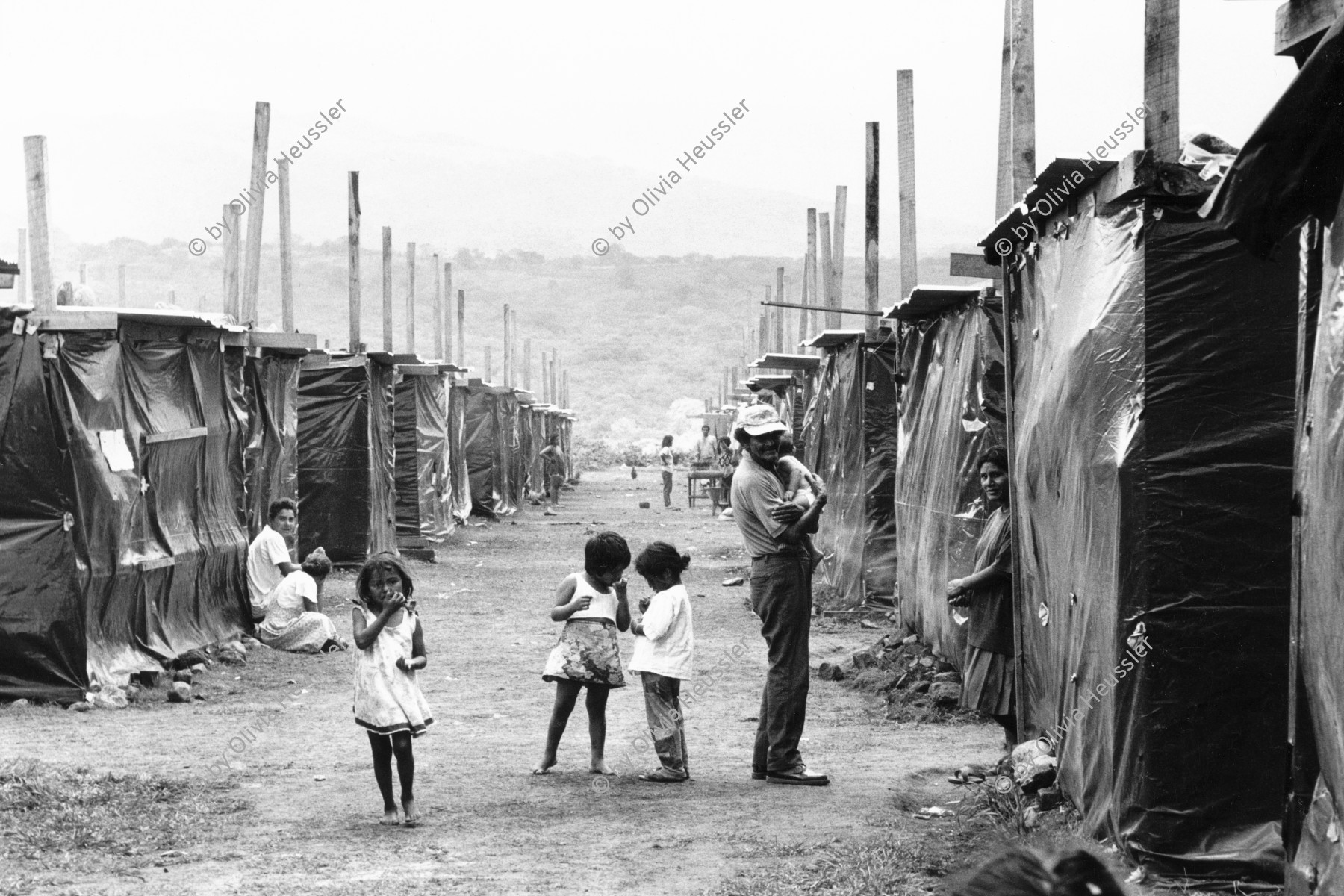 Image of sheet 19990040 photo 17: Opfer des Hurrikans Hurracan Mitch wohnen während der Regenzeit in Zelten mit schwarzen Plasitik plachen hütten.
Victims of Hurricane Mitch live in tents during the rainy season with black tarpaulins Plasitik huts.
Esteli Nicaragua Barrio Nuevo Amanecer, Mai 1999

√ © 1999, Olivia Heussler