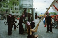 Image of sheet 20020190 photo 3: 1. Mai Demo Demonstration  gegen Busch George Bush Masken Affen Köche Koch Kochen ehemaliger Tessiner Nationalrat der Sozialdemokraten Franco Cavalli an der Demo am Limmatquai füttert Frau Tauben. 
Gotthard Wilhem Tell Abbildung auf Smart Auto Autobahn Galerien im Regen
