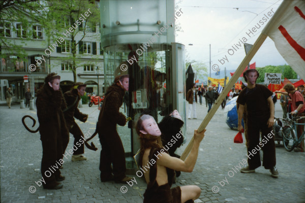 Image of sheet 20020190 photo 3: 1. Mai Demo Demonstration  gegen Busch George Bush Masken Affen Köche Koch Kochen ehemaliger Tessiner Nationalrat der Sozialdemokraten Franco Cavalli an der Demo am Limmatquai füttert Frau Tauben. 
Gotthard Wilhem Tell Abbildung auf Smart Auto Autobahn Galerien im Regen