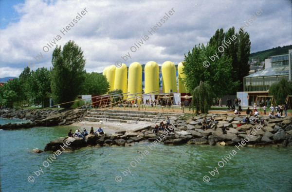 Image of sheet 20020210 photo 13: Ausflug Expo.02 mit Redaktion der Schweizer Familie Tamedia Schiff nach Neuenburg Sicht vom See Stäbe Neuchatel Die drei Kieselsteine auf der Arteplage Neuenburg 2002
Die Expo.02 war die 6. Schweizer Landesausstellung und fand vom 15. Mai bis zum 20. Oktober 2002 im Drei-Seen-Land statt. Die Ausstellung bestand hauptsächlich aus fünf Arteplage genannten Ausstellungsgeländen, welche an den Seeufern der Städte Biel/Bienne, Murten, Neuenburg und Yverdon-les-Bains ausschliesslich für die Dauer der Exposition errichtet wurden; die fünfte Arteplage war eine umgebaute Kiesbarke, Arteplage mobile du Jura genannt, die zwischen den restlichen Arteplages verkehrte. Dabei vertrat jede Arteplage einen der fünf Organisations-Kantone Bern, Jura, Freiburg, Neuenburg und Waadt.
Alis Heussler 4 1/2 jährig und Olivia Apfelsorten alte in Konfitüregläser Gläser Apfel Riesenrad Coop

Expo.02 was the 6th Swiss national exposition, which was held from 15 May to 20 October 2002. The exposition took place around the lakes of Neuchâtel, Bienne/Biel and Morat/Murten. It was divided into five sites, which were called Arteplages, due to the proximity of the water (some sites were actually partially or totally built on the water). The five Arteplages were located in Neuchâtel, Yverdon-les-Bains, Morat/Murten, Biel/Bienne and on a mobile barge traveling from one site to another. The barge represented the canton of Jura, which does not have access to any one of the three lakes. Switzerland Schweiz 2002