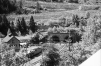 Image of sheet 20020360 photo 11: Tunnel Gotthardbahn Göschenen Brücke Nationalstrasse Michael T. Ganz Verkehrsschilder
Haederlisbruecke untere Schoellenen Bahngeleise der Gotthard Eisenbahn vor dem Tunneleingang
Urnerland Römerbrücke 
In der Nacht vom 24. auf den 25. August 1987 wurde das Gotthard-Gebiet durch ein Unwetter mit heftigen Niederschlägen heimgesucht. Das dadurch entstandene Hochwasser in der Reuss schwemmte die für ihre Schönheit weitherum bekannte Häderlisbrücke in der Schöllenen weg. 1991 hat der Kanton Uri mit Hilfe des Bundes und des Schweizerischen Baumeisterverbandes die Häderlisbrücke originalgetreu wiederaufgebaut.
