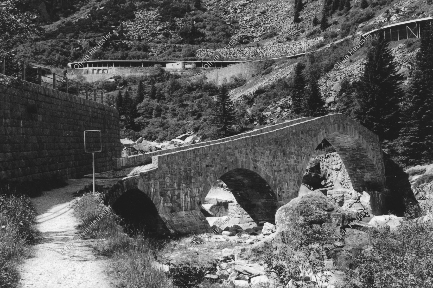 Image of sheet 20020360 photo 28: Gotthardbahn Göschenen Brücke 
Haederlisbruecke untere Schoellenen Bahngeleise der Gotthard Eisenbahn vor 
Urnerland Römerbrücke Kanton Uri, Schweiz  2002 √

In der Nacht vom 24. auf den 25. August 1987 wurde das Gotthard-Gebiet durch ein Unwetter mit heftigen Niederschlägen heimgesucht. Das dadurch entstandene Hochwasser in der Reuss schwemmte die für ihre Schönheit weitherum bekannte Häderlisbrücke in der Schöllenen weg. 1991 hat der Kanton Uri mit Hilfe des Bundes und des Schweizerischen Baumeisterverbandes die Häderlisbrücke originalgetreu wiederaufgebaut.