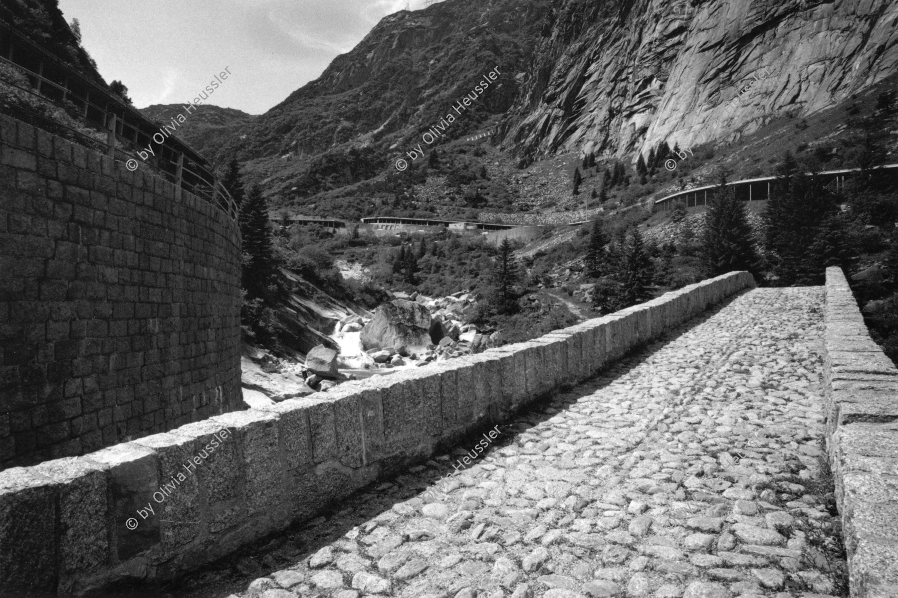 Image of sheet 20020360 photo 30: Haederlisbruecke untere Schoellenen bridge roman
Urnerland Römerbrücke 
In der Nacht vom 24. auf den 25. August 1987 wurde das Gotthard Gebiet durch ein Unwetter mit heftigen Niederschlägen heimgesucht. Das dadurch entstandene Hochwasser in der Reuss schwemmte die für ihre Schönheit weitherum bekannte Häderlisbrücke in der Schöllenen weg. 1991 hat der Kanton Uri mit Hilfe des Bundes und des Schweizerischen Baumeisterverbandes die Häderlisbrücke originalgetreu wiederaufgebaut. √ Uri Schweiz Switzerland