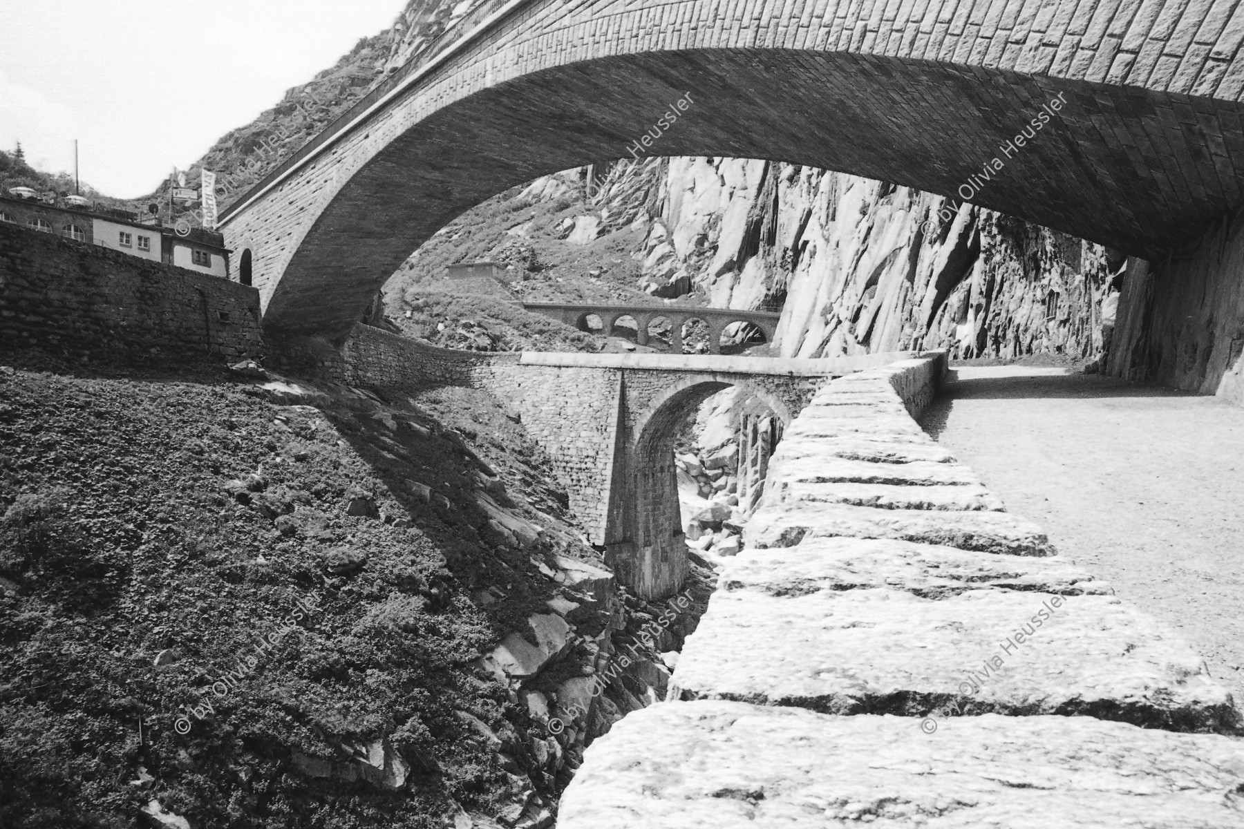 Image of sheet 20020380 photo 1: Gotthardstrasse Schöllenen Strassenbrücke von 1956 überspannt jene von 1830 die Säumerbrücke oder Teufelsbrücke genannt von 1200 befand sich ganz unten in der Schlucht. beim Suwarow-Denkmal Memorial
Urnerloch erstes Tunnel weltweit

copyright by © 2002, OLIVIA HEUSSLER / www.clic.li

General Alexander Wassiljewitsch Suworow (1729–1800) 
Am 24. September 1799 eroberte er in einer Schlacht den St. Gotthard-Pass von den Franzosen
Gotthard Gotthardpass Brücke Schlucht Reuss Uri 2002 Exhibition »Via Gotthard«, Leica Camera Galerie Bienne 2003