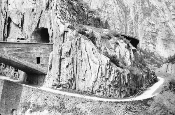 Image of sheet 20020400 photo 1: Gotthardstrasse Schöllenen Strassenbrücke von 1956 überspannt jene von 1830 die Säumerbrücke von 1200 befand sich ganz unten in der Schlucht. Viadukt Schöllenenbahn Teufelsbrücke Suwarow-Denkmal Memorial  
Urnerloch erstes Tunnel der Schweiz.
Kletterer am Klettersteig
Schülergruppe Touristen Andermatt Militärkaserne militärisches Uebungsgebiet Mic Ganz Michael
Urserental Felder Rentner Alois Regli mit Frau und Freunden vor dem 'Sybfiggler' auf Bank in Andermatt Eingang Bunker im Feld am Berg Kanton Uri, Schweiz Switzerland
Heute baut dort der ägyptische Bauunternehmer Samih Sawiri ein Ferien-resort.
aus: Gotthard, das Hindernis verbindet.