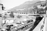 Image of sheet 20020550 photo 3: Airolo Bahnlinie Eingang Zugtunnel Gotthard Lastwagen Fahrradmiete Denkmal für die Opfer des Zugtunnelbau Traforo del Gottardo Ausschnitt  Stiefel und Hand alte Lokomotive