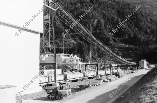 Image of sheet 20020760 photo 29: Gotthard Basistunnel Neat Bahntunnel im Beisein
Peter Zbinden nr. 8 Vorsitzender der Geschäftsleitung AlpTransit Gotthard AG 
Svp Altbundesrat Adolf Dölf Ogi  0-2 
Tunnelarbeiter Gruppenbild in Uniformen Garderobe Aushub Material neg. nr. 12 li Adolf Ogi mit Olivia Heussler re. Marc Valance 
Barakendorf der Arbeiter 
aus: Gotthard, das Hindernis verbindet.
Kanton Uri, Schweiz Svizzera, Switzerland