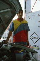 Image of sheet 20030030 photo 20: Pakistan 'Piyo aur jiyo!' Drinke und Lebe! Néstle wirbt an einer Hauswand für ihr Trinkwasser 
Gasbetriebene Fahrzeuge Autos mit Gas Tankstelle Love is life steht an einer Mauer dahinter Gras Marihuana pflanzen wilde Verkehrskreisel mit Atombombe