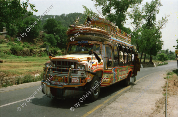 Image of sheet 20030030 photo 30: Pakistan 'Piyo aur jiyo!' Drinke und Lebe! Néstle wirbt an einer Hauswand für ihr Trinkwasser 
Gasbetriebene Fahrzeuge Autos mit Gas Tankstelle Love is life steht an einer Mauer dahinter Gras Marihuana pflanzen wilde Verkehrskreisel mit Atombombe