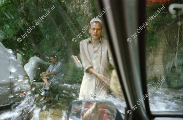 Image of sheet 20030030 photo 36: Pakistan 'Piyo aur jiyo!' Drinke und Lebe! Néstle wirbt an einer Hauswand für ihr Trinkwasser 
Gasbetriebene Fahrzeuge Autos mit Gas Tankstelle Love is life steht an einer Mauer dahinter Gras Marihuana pflanzen wilde Verkehrskreisel mit Atombombe