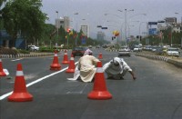 Image of sheet 20030030 photo 8: Pakistan 'Piyo aur jiyo!' Drinke und Lebe! Néstle wirbt an einer Hauswand für ihr Trinkwasser 
Gasbetriebene Fahrzeuge Autos mit Gas Tankstelle Love is life steht an einer Mauer dahinter Gras Marihuana pflanzen wilde Verkehrskreisel mit Atombombe