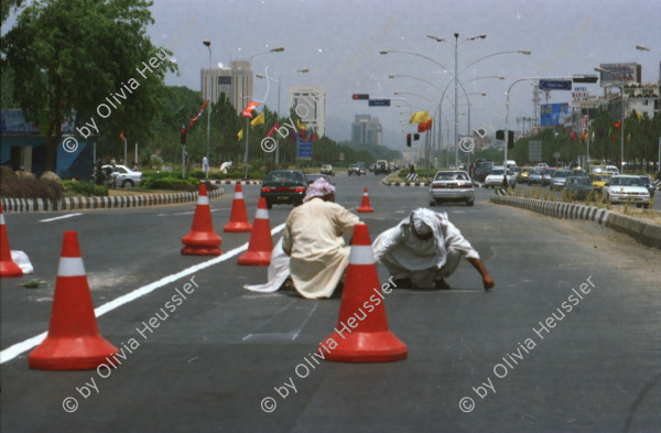 Image of sheet 20030030 photo 8: Pakistan 'Piyo aur jiyo!' Drinke und Lebe! Néstle wirbt an einer Hauswand für ihr Trinkwasser 
Gasbetriebene Fahrzeuge Autos mit Gas Tankstelle Love is life steht an einer Mauer dahinter Gras Marihuana pflanzen wilde Verkehrskreisel mit Atombombe