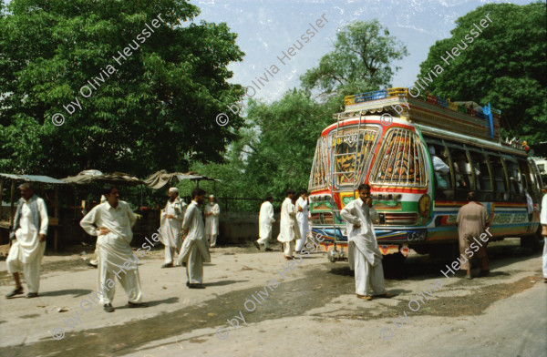 Image of sheet 20030040 photo 12: Autobus Car Transport auf der Strasse von der Hauptstadt Islamabad nach Murree M. ist eine Kleinstadt in der Provinz Punjab in Nord-Pakistan
Leute Männer und ein Mädchen beim Wasser holen am Tanklastwagen. Frauen Holztransport Lastwagen beschmückt Linksverkehr Bäume im Galyat tal