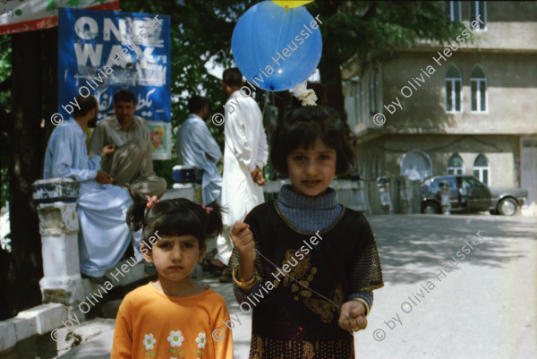 Image of sheet 20030050 photo 17: Murree ist eine Kleinstadt in der Provinz Punjab in Nord-Pakistan
Kinder mit farbigen Ballonen Hotel alter Mann und Schimmel weisses Pferd steht am Eingang Blecksoldaten zum abknallen mit dem Luftgewehr Spiel alte Bäume