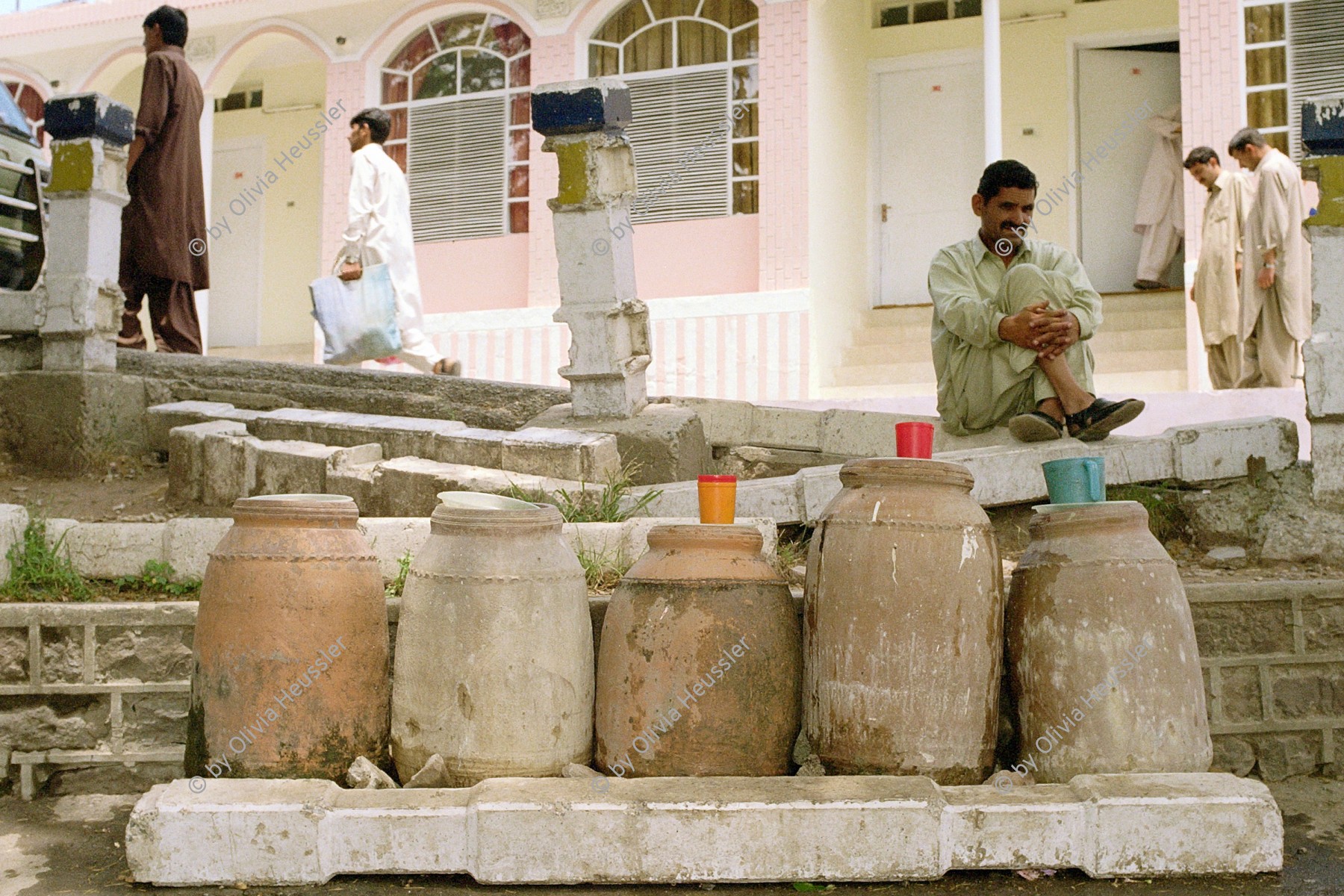 Image of sheet 20030060 photo 10: Murree ist eine Kleinstadt in der Provinz Punjab in Nord-Pakistan 
Pakistan Im Schatten stehen Wassergefaesse. Ein Mann verkauft Trinkwasser.
Wasser,