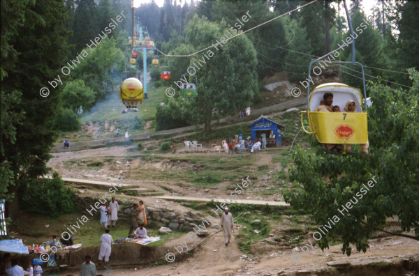 Image of sheet 20030080 photo 8: Ayubia is a small town in the Khyber-Pakhtunkhwa province of Pakistan. It is located near the Murree hills and Galyat and is home to Ayubia National Park. It is a very famous tourist destination and includes one of the oldest chair lifts of the area.
Leute Männer und Frauen fahren auf den Berg in einer der  Bäume im Galyat tal
(eine der ältesten) Gondelbahn auch für Familien im National Park. Junges Paar auf dem Spielplatz Sicht auf die Berge des Kashmir Talstation Gondelbahn Junge Pakistani