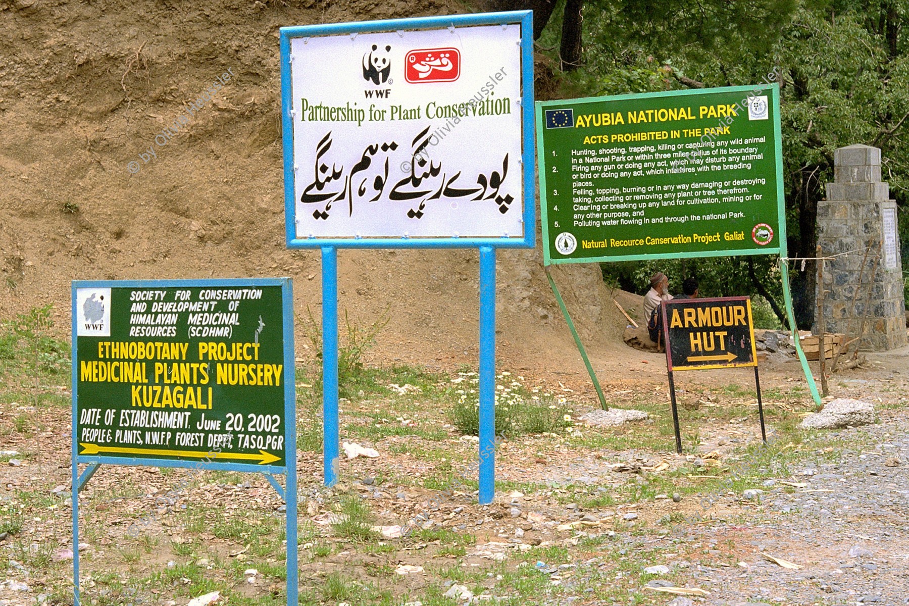 Image of sheet 20030100 photo 3: Ayubia is a small town in the Khyber-Pakhtunkhwa province of Pakistan. It is located near the Murree hills and Galyat and is home to Ayubia National Park. It is a very famous tourist destination
Pakistan 23/05/2003 entering Ajubia National Park. Parkguide having a break.

Signs of WWF and others. ngo 23/05/2003