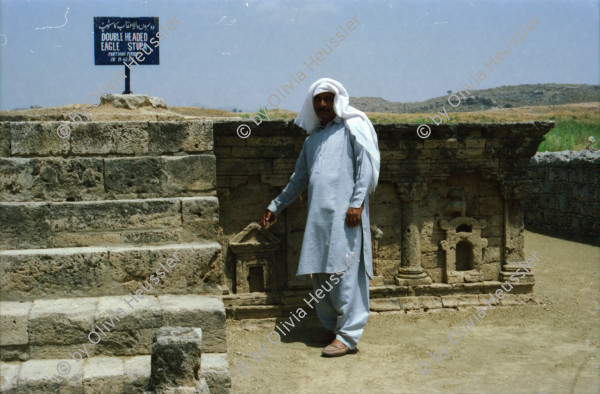 Image of sheet 20030120 photo 16: Sirkap (Urdu: سر کپ) is the name of an archaeological site on the bank opposite to the city of Taxila, Punjab, Pakistan. The city of Sirkap was built by the Greco-Bactrian king Demetrius after he invaded ancient Pakistan around 180 BC. Demetrius founded in the northern and northwestern Indian subcontinent (modern day Pakistan) an Indo-Greek kingdom that was to last until around 10 BC. Sirkap is also said to have been rebuilt by king Menander I. Wasserbrunnen, Mauern Mann im Schatten restauriert In den Stupas Nr. 14a wurden die Mönche eingeäschert. Männer baden schwimmen Khanpurkanal in einem Wasserkanal der Wasser nach Islamabad bringt. Eine Familie recycles sammelt Petflaschen und Abfall.