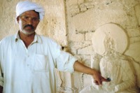 Image of sheet 20030130 photo 4: Islamabad
Jaulian (Urdu: جھولیاں) are the ruins of an ancient buddhistic monastery near Taxila, Punjab (Pakistan), Pakistan. 
Mann steckt seinen Finger in den Nabel des Budas, dies sollte ihm Glück bringen.
Buddhas ohne Gesicht, es wurde zerstört.

Taxila (griechische Form des Namens; eigentlich Sanskrit, तक्षशिला, f. Takṣaśilā, Takshashila; wörtl: „Hügel des Taksha“, Pali: Takkasilā) war die historische Hauptstadt des Reiches Gandhara, das sich über die östlichen Gebiete des heutigen Afghanistan und den Nordwesten Pakistans erstreckte. Taxila erlebte seine Blütezeit vom fünften vorchristlichen bis zum fünften Jahrhundert unserer Zeit. 
 Seit 1980 werden die archäologischen Stätten des früheren Taxila von der UNESCO als Weltkulturerbe gelistet.