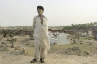 Image of sheet 20030170 photo 36: Im Flüchtlingslager des UNHCR für afghanische Flüchtlinge in Islamabad. F-11
OBJE_Pakistan: Islamabad, Slum F-11. Afghan Refugee stand in front of the graveyard.The Camp is  runned by UNHCR 26/05/2003 Pakistan: Afghanischer Flüchtling auf dem Friedhof im Flüchtlingslager