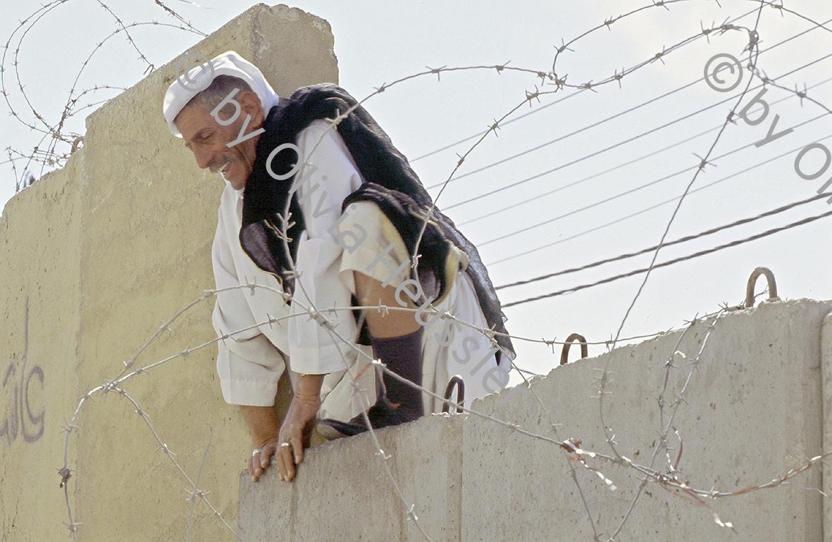 Image of sheet 20031023 photo 0: Palästinenser klettert im letzten Moment vor der Trennung des Dorfes Abu-Dis zu Jerusalem, über eine Mauer, 2003.
Mauerbau bei Abu-Dis, Jerusalem 2003.