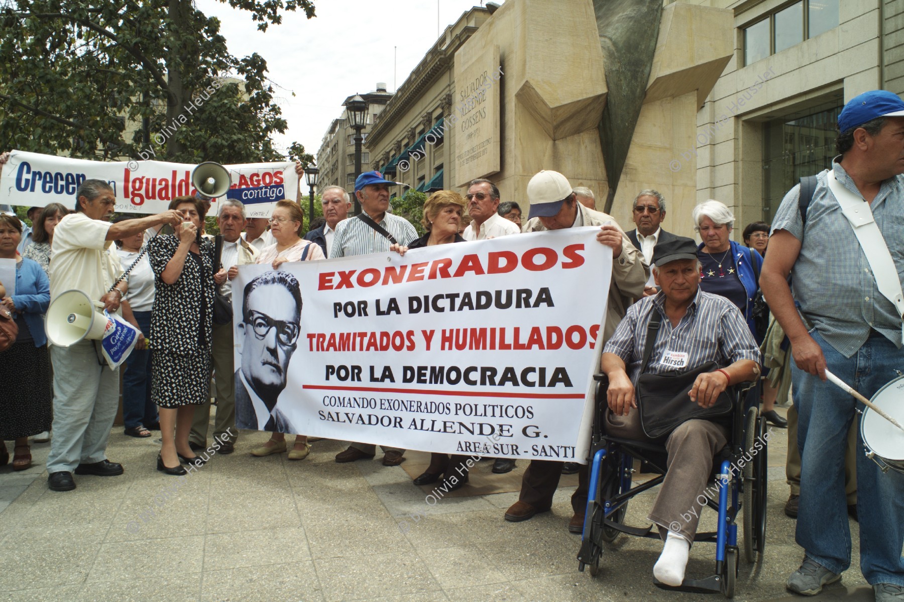 Image of sheet 20051129 photo 52: Former employees and workers laid off during Pinochet era protest outside the La Moneda for an appropriate pension. 
Santiago de Chile 2005 Banner Allende Salvador Exonerados