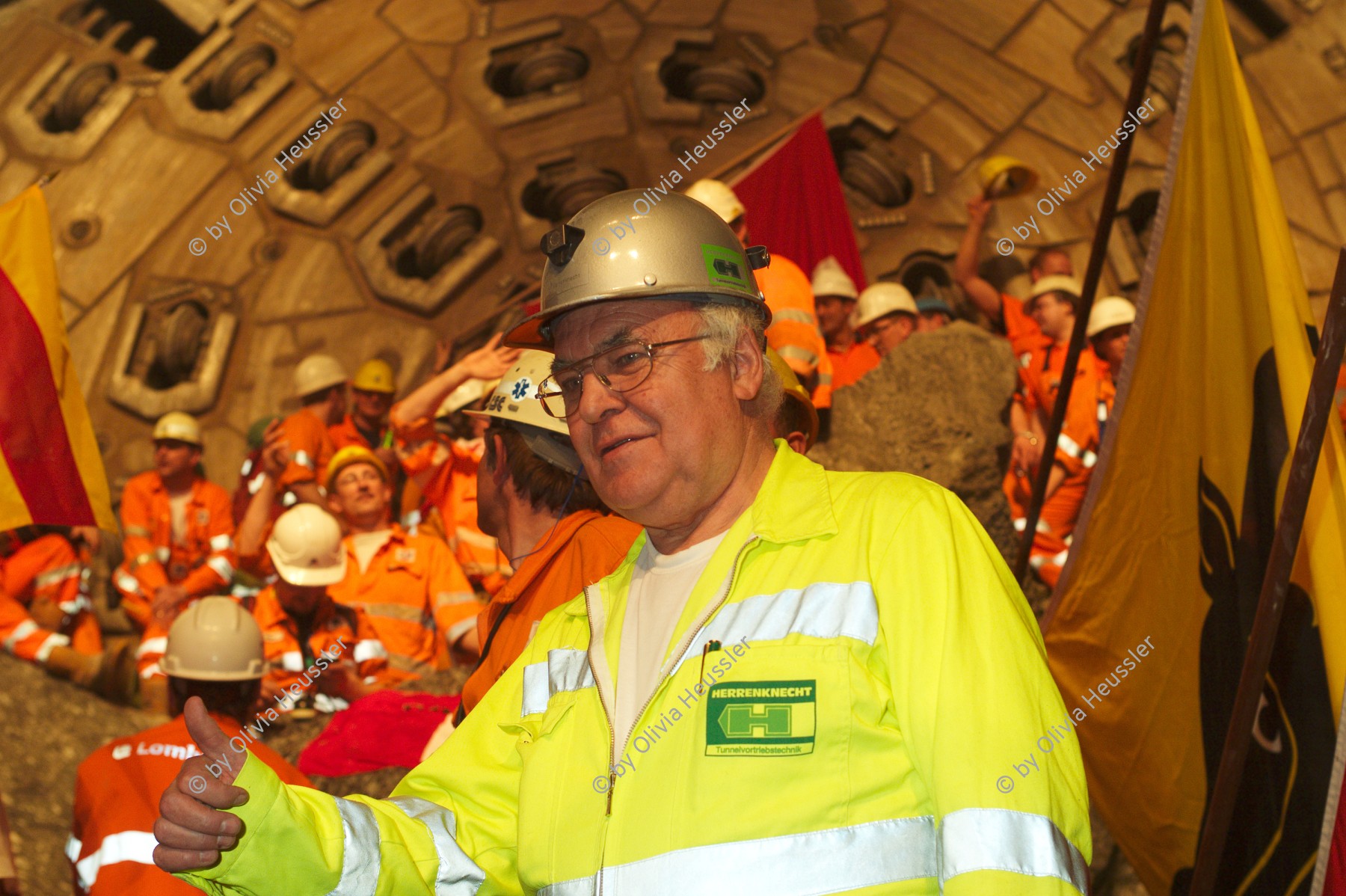 Image of sheet 20110323 photo 710: Hans Dieter Herrenknecht vor der Tunnelbohrmaschine Heidi. 

Miners celebrate after the tunnel drilling machine "Heidi" breaks through the last section of the Gotthard Base Tunnel West near Sedrun in the canton of Grisons, Switzerland, Wednesday, March 23, 2011. 
..Die Mineure feiern nach dem 2. Hauptdurchschlag (Durchstich Neat) im Gotthardbasistunnel in Sedrun, vor der Tunnelbohrmaschine "Heidi" Mittwoch, 23. Maerz 2011. Wie geplant sind am Mittwoch die letzten Meter Fels im Gotthard-Basistunnel durchstossen worden. damit ist auch die Westroehre zwischen Erstfeld und Bodio auf der gesamten Laenge von 57 Kilometern ausgebrochen. am Mittwoch, dem 23. März 2011, starteten die Mineure am längsten Eisenbahntunnel der Welt ein letztes Mal die Herrenknecht-Tunnelbohrmaschine »Heidi« (Gripper-TBM, Durchmesser 9,43 m). Nach insgesamt 25,2 km fiel um 12:20 Uhr die Felswand beim Durchbruch. Damit ist der Weg durch die Alpen durchgängig frei.
After the tunnel drilling machine "Heidi" broke through the last section of the Gotthard Base Tunnel near Sedrun in the canton of Grisons, Switzerland. With 57 kilometre (35-mile) the new St. Gotthard tunnel is the world's longest tunnel. The 13,157 billion Swiss franc (9,6 billion euros, 13,6 billion dollars) Alptransit project, which is due to be operational in 2016, constitutes the center piece of the New Railway Link through the Alps NRLA. √