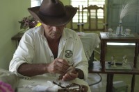 Image of sheet 20140211 photo 82: Ein Mann mit Cowboyhut packt Zigarren in ein Blatt. Tabak Vinales Cuba 2014