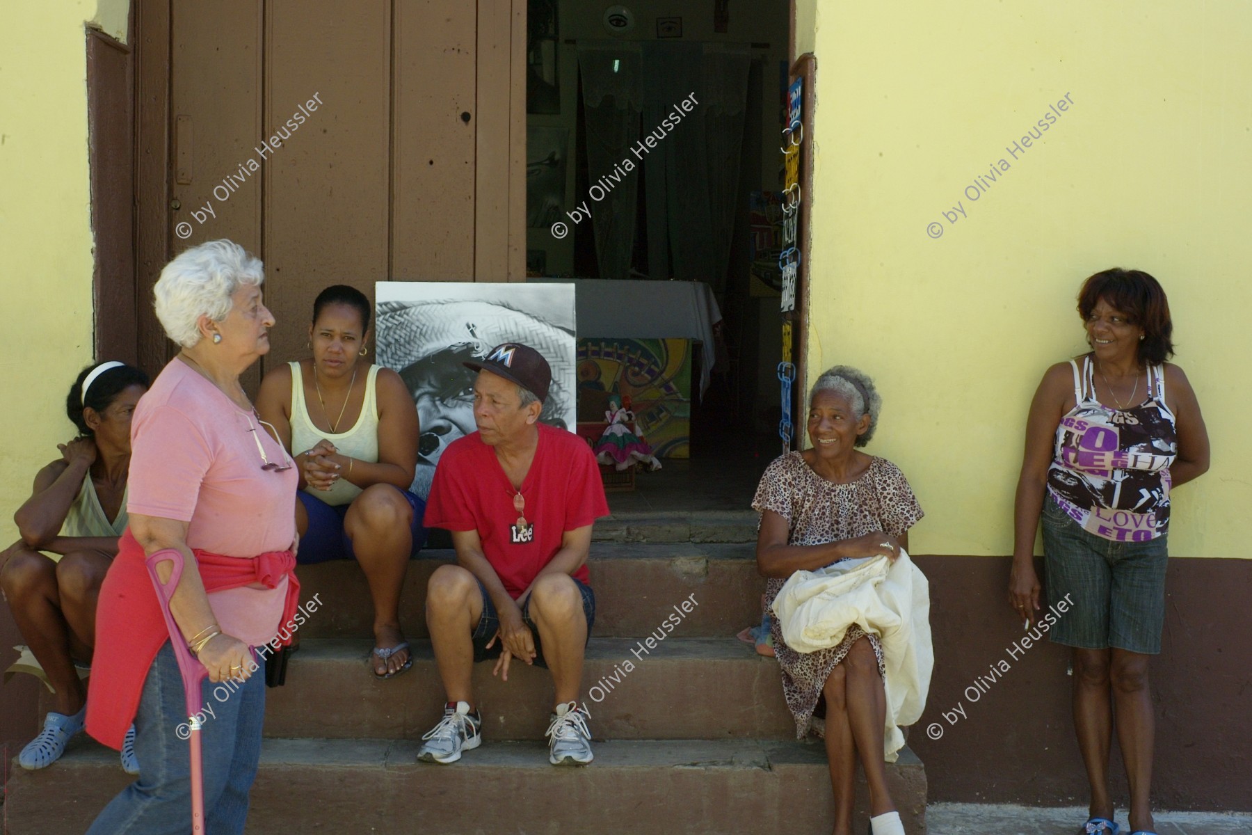 Image of sheet 20140215 photo 13: Menschen sitzen vor einem Laden in der Altstadt Trinidads auf einer Treppe im Schatten und warten auf Touristen.Trinidad Kuba 2014