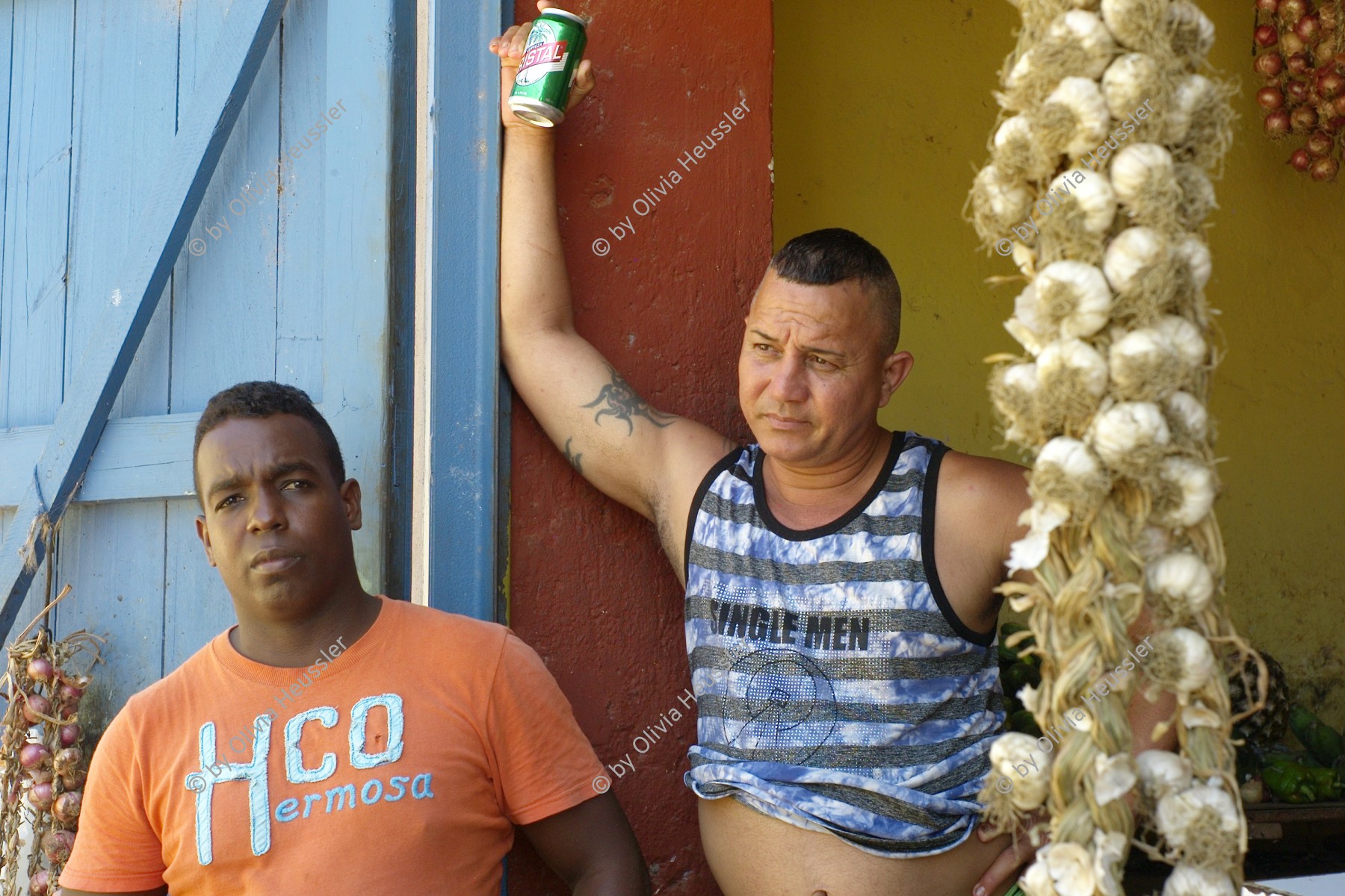 Image of sheet 20140215 photo 19: Zwei Männer verkaufen an einem Stand Knoblauch zöpfe und einer trinkt Bier aus einer Aludose. Kuba Trinidad 2014