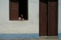 Image of sheet 20140215 photo 91: Eine Frau steht in der Sonne am Fenster Trinidad Kuba 2014