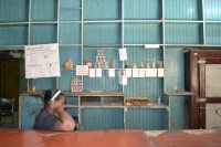 Image of sheet 20140219 photo 67: Frau sitzt In einer kubanischen «Bodega libretta» wo die Bevölkerung mit der Rationierungskarte einkaufen kann.  Kuba Havanna 2014 Cuba La Habana 
Rationierung Embargo